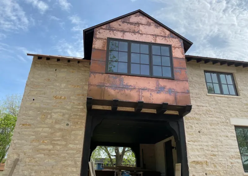 Copper metal panel facade on a stone building for Skylight Installation in Bend